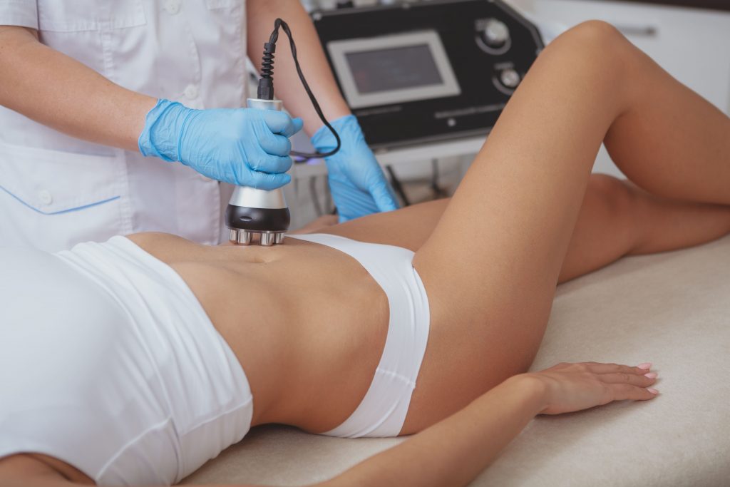 A person receiving RF contouring treatment on their abdomen at a spa.